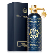 A 100ml bottle of Montale Paris Infinity EDP by Montale Paris is displayed beside its navy and gold packaging, featuring a geometric-patterned bottle adorned with a gold charm.