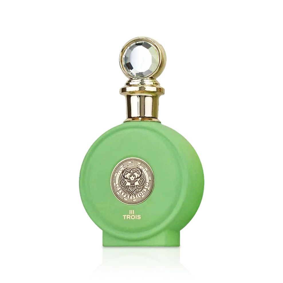 The Paris Corner North Stag Expressions - III TROIS 100ml Eau De Parfum features a round green bottle with a gold medallion and clear faceted cap. The label says "III TROIS" in gold, reflecting an elegant, sophisticated fragrance for men and women.
