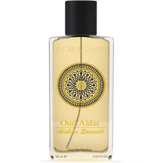 A transparent bottle of Rio Perfumes' "AL Musbah Oud Aldar Arabian Souvenir 90ml Eau De Parfum" with a decorative circular label, containing yellow liquid, against a white background.