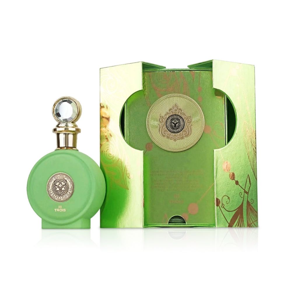 A Paris Corner North Stag Expressions - III TROIS 100ml EDP perfume bottle in green with a gold emblem is positioned beside its coordinating green and gold decorative box on a white background, presenting a sophisticated unisex fragrance—an elegant selection from Paris Corner.