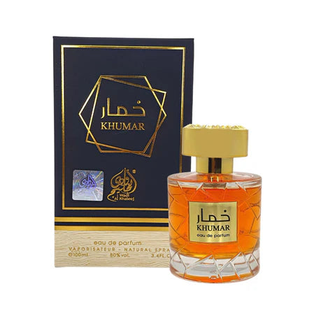 A bottle of Khumar Sugar Wadi Al Khaleej 100ml EDP by Lattafa, featuring amber-hued perfume, is displayed in front of its black and gold box, highlighting this aromatic spicy fragrance.