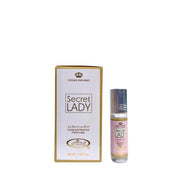 A small bottle of Crown Perfumes Al-Rehab Secret Lady concentrated oil perfume is shown next to its elegant white and gold packaging.