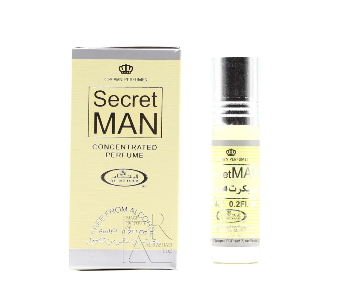 A box and a small bottle of Crown Perfumes Al-Rehab Secret Man concentrated oil perfume, both featuring yellow and black design elements and labeled with the Crown Perfumes brand.