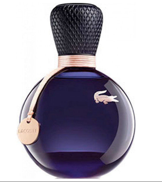 Lacoste Eau De Lacoste Sensuelle 50ml Eau De Parfum comes in a round, deep purple bottle with a textured black cap, gold emblem, and gold tag—a sophisticated women's fragrance from Lacoste.