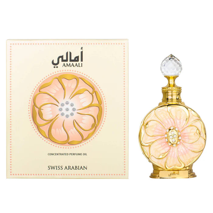 The Swiss Arabian Amaali 15ml Concentrated Oil is shown next to its cream-colored box adorned with a large pink flower, reflecting the perfume's floral woody musk character.