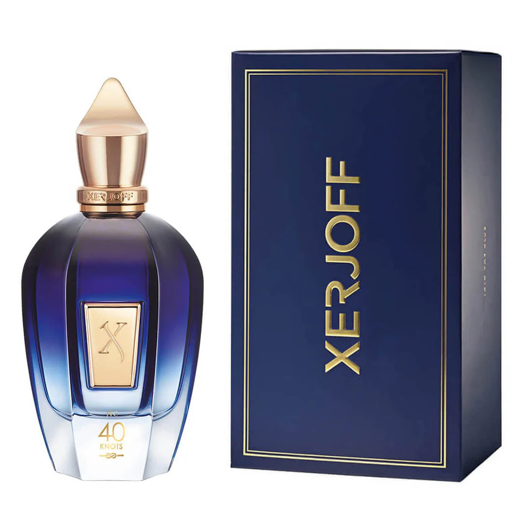 A blue bottle of Xerjoff 40 Knots 100ml EDP with a gold cap is displayed next to its matching blue and gold box from XERJOFF’s Join the Club Collection.