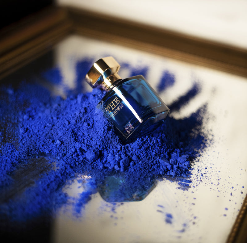 Load image into Gallery viewer, A bottle of Byron Parfums The Chronic Narcotic Collection 75ml Extrait De Parfum, containing a vibrant blue powder, placed delicately on top of a mirror.
