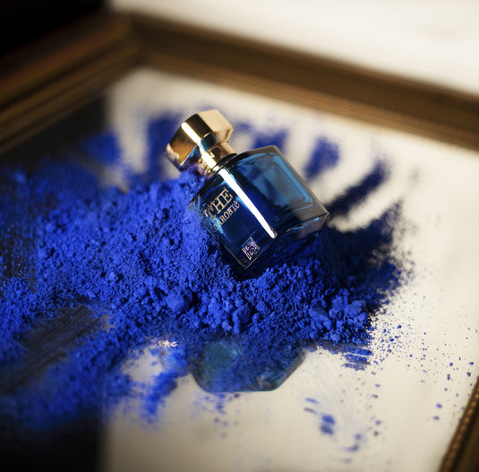 A bottle of Byron Parfums The Chronic Narcotic Collection 75ml Extrait De Parfum, containing a vibrant blue powder, placed delicately on top of a mirror.