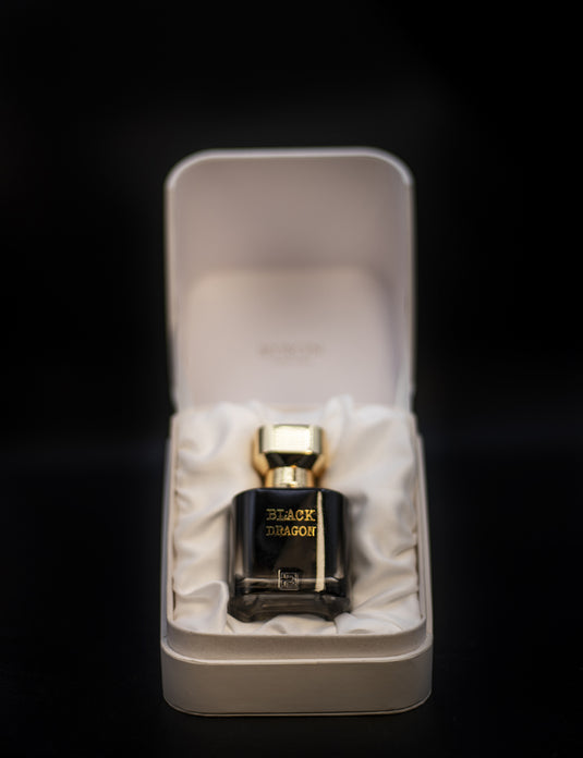 An exquisite Byron Parfums Black Dragon 75ml Extrait De Parfum, elegantly presented in a white box, resting on a sleek black surface.