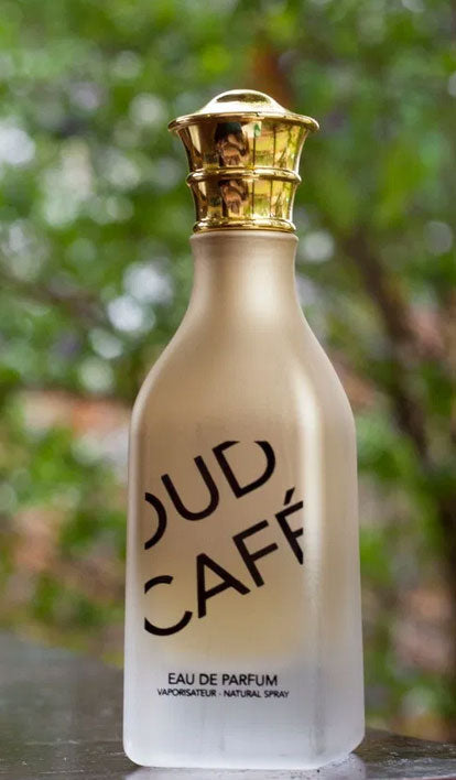 A bottle of Fragrance World Cafe Oud 85ml Eau de Parfum sitting on a table.