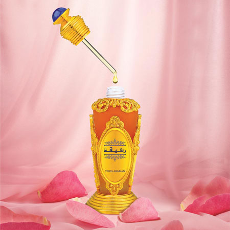 Load image into Gallery viewer, A 20ml bottle of Swiss Arabian Rasheeqa 20ml Concentrated Perfume Oil, a product by the brand Swiss Arabian, is being poured onto a pink background.
