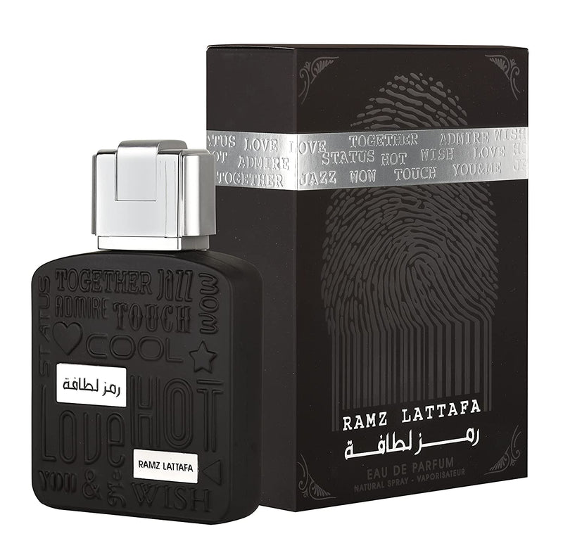 Load image into Gallery viewer, A bottle of Lattafa Ramz Silver 100ml Eau de Parfum with a box in front of it.
