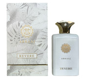 A white and gold bottle of Paris Corner Abraaj Revere 100ml EDP stands beside its matching box with leaf patterns and gold accents, reflecting the elegant woody spicy character of this Paris Corner fragrance.