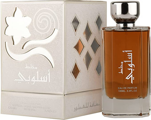 A bottle of Lattafa Mukhallat Asloobi 100ml Eau De Parfum by Lattafa, with a box in front of it, emitting a captivating fragrance.