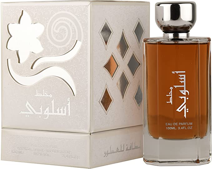 Load image into Gallery viewer, A bottle of Lattafa Mukhallat Asloobi 100ml Eau De Parfum by Lattafa, with a box in front of it, emitting a captivating fragrance.
