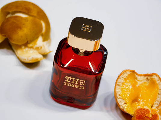 A bottle of Byron Parfums The Chronic 75ml Extrait De Parfum from Byron Parfums next to oranges.