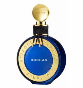 A round blue perfume bottle with a gold cap and label, branded "Rochas Byzance 90ml EDP" by Rochas, and the word "BYZANCE" encircling the label. This elegant fragrance for women features an enchanting Amber Floral aroma.