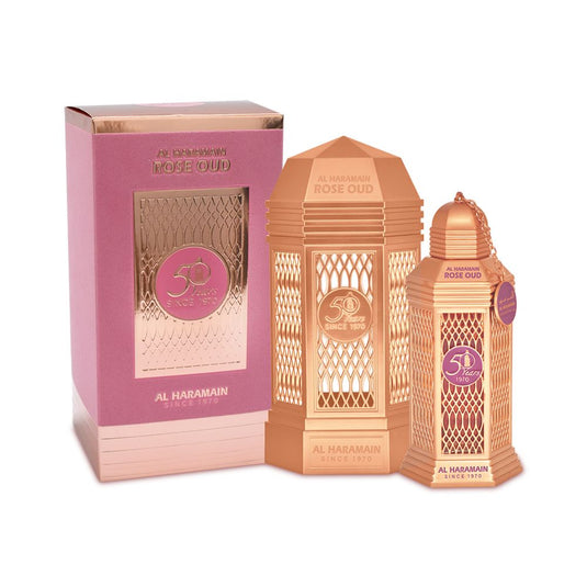 An Al Haramain 50 Years Rose Oud Spray 100ml Eau De Parfum bottle in the shade of pink, accompanied by an elegant box.