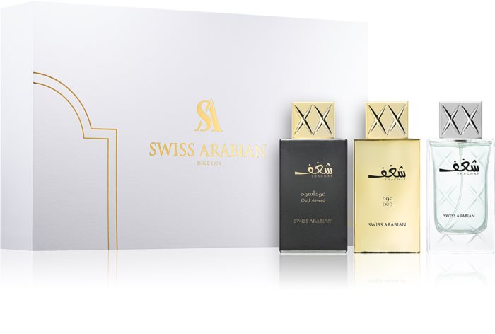The Swiss Arabian Shaghaf 3 Piece Gift Set features elegant black, gold, and clear glass bottles of Shaghaf Oud and Shaghaf Eau de Parfum, beautifully presented before a luxurious white and gold gift box.